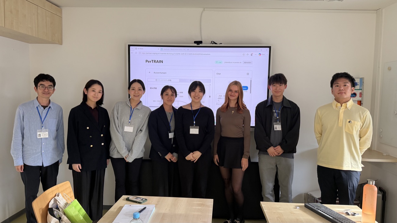 Gruppenbild der Studierenden aus Japan vor einem Bildschirm, auf dem die japanische Fassung von PerTRAIN läuft